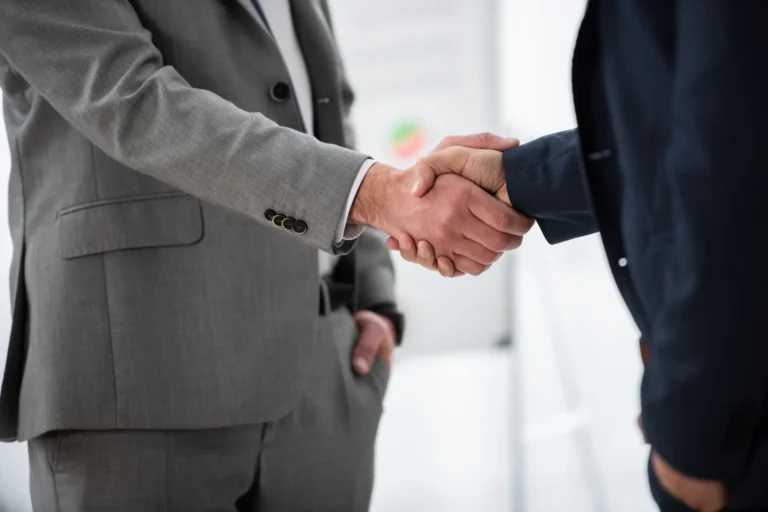 cropped shot of businessmen in formal wear shaking hands in Riveros Corp