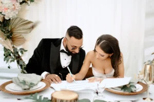 Bride and groom signing marriage documents at their wedding reception