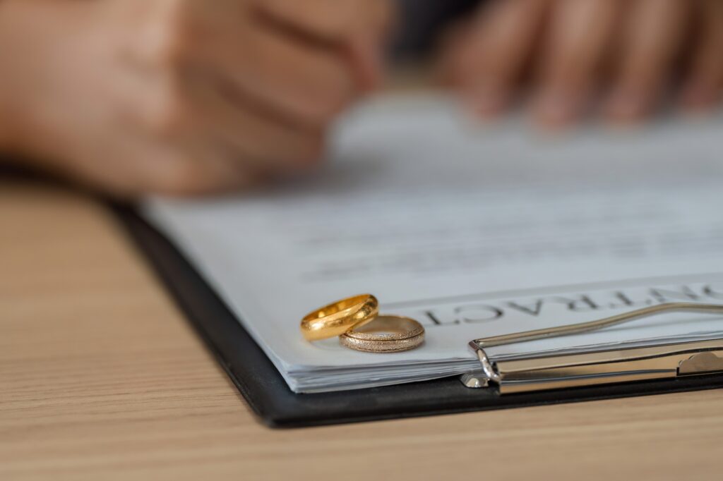 Wedding rings placed on top of legal documents signify a separation.